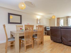 a dining room and living room with a table and chairs at 6 Harbour View in Newquay +12 photos