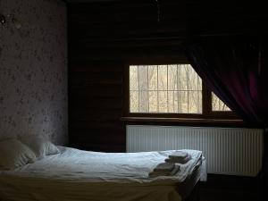 a bedroom with a bed with a window and towels at Готельно-ресторанний комплекс Загадка in Khmelʼnytsʼkyy +8 photos