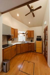 a kitchen with wooden cabinets and a ceiling fan at やまぽっちYamapochi Cottage in Hakuba