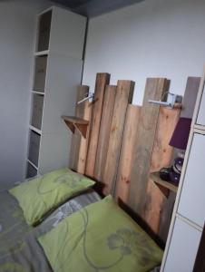 a bedroom with a bed and a wooden wall at Le Charme des Barcarelles in Le Barcarès