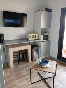 a small kitchen with a table and a microwave at Le Charme des Barcarelles in Le Barcarès +11 photos