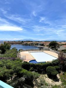 a view of a swimming pool and a river at Le Charme des Barcarelles in Le Barcarès