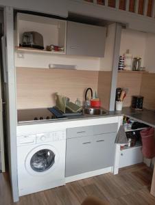 a kitchen with a washing machine and a sink at Le Charme des Barcarelles in Le Barcarès