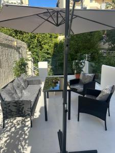 a patio with an umbrella and chairs and a table at JOHNMAR apartment in Athens +9 photos