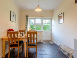 a dining room with a table and chairs and a window at The Milking Shed - Uk30436 in Kingsbury Episcopi