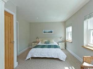 a bedroom with a bed and two windows at Eddystone Row 2 in Salcombe
