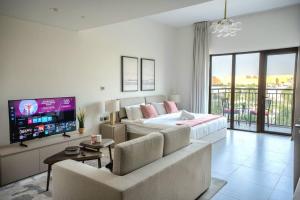 a living room with a bed and a couch and a tv at Studio on Yas Island with Big Balcony, Near F1, Water Park and Ferrari view in Abu Dhabi