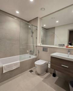 une salle de bains avec baignoire, toilettes et lavabo dans l'établissement Studio on Yas Island with Big Balcony, Near F1, Water Park and Ferrari view, à Abu Dhabi 7 autres photos