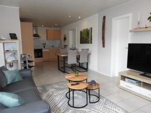 a living room with a couch and a tv and a table at Ferienwohnung "Schöne Aussicht" in Reil +23 photos