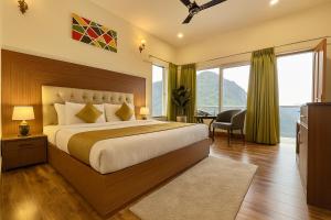 a bedroom with a large bed with a large window at The Kempty Emerald - A Wellness Boutique Hotel, Mussoorie in Mussoorie +23 photos