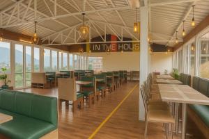 a dining room with tables and chairs and windows at The Kempty Emerald - A Wellness Boutique Hotel, Mussoorie in Mussoorie
