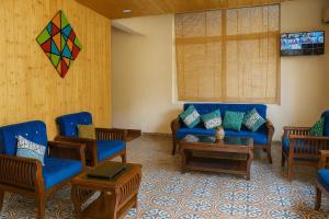 a living room with a couch and chairs and a kite at The Kempty Emerald - A Wellness Boutique Hotel, Mussoorie in Mussoorie