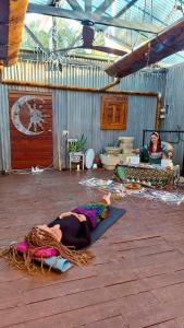 a woman is laying on a mat in a room at One Life Live It Farm stay Retro VanStay in Dareton