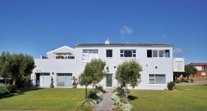 una casa blanca con un patio delante en Lieflappie❤, en Stilbaai