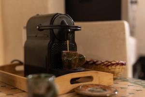 eine Kaffeemaschine, die Kaffee in eine Tasse auf einem Tisch schüttet in der Unterkunft Riad Privé Dar El Khamsa-Petit Dej inclus in Marrakesch + 52 Fotos