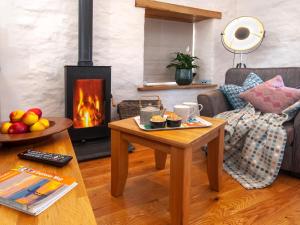 a living room with a coffee table and a fireplace at The Loft - Cottage in Letterston