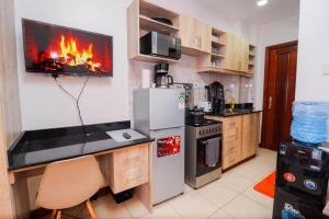 una cucina con piano cottura e una TV a parete di South suits furnished apartments a Nairobi