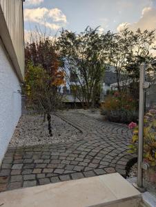 a cobblestone walkway in a garden with trees at Renovierte Wohnung in 8903 Birmensdorf in Birmensdorf +21 photos