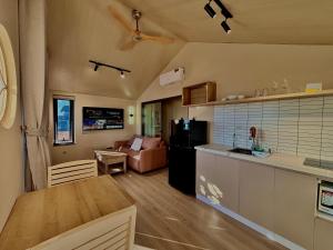 会安Palmera Hoi An Villa & Apartment的配有桌子和沙发的厨房和客厅