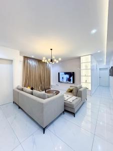 a living room with two couches and a tv at Dateheight Apt in Lekki