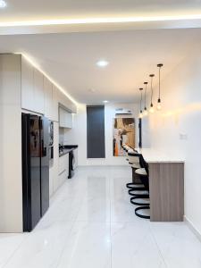 a white kitchen with a counter and a row of stools at Dateheight Apt in Lekki