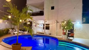 达喀尔Jade guest House的旁边是一座棕榈树的大型游泳池