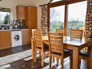 a kitchen with a wooden dining table and chairs at Swallows Nest in Soulby