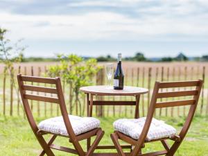 a table with a bottle of wine and two chairs at Olive in Wootton Bridge