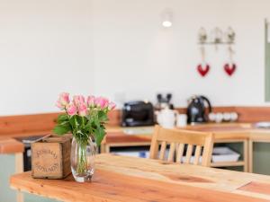 a vase of pink flowers sitting on a wooden table at Olive in Wootton Bridge +10 photos