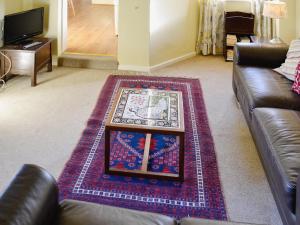a living room with a couch and a table at Bat's Cottage in Tipton Saint John