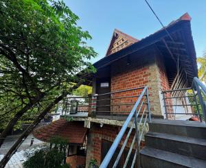 a brick building with a balcony and stairs at Escape Inn in Trivandrum