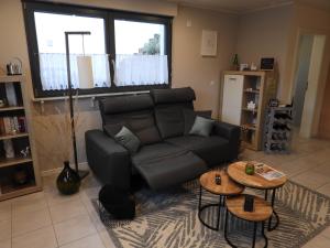 a living room with a black couch and two tables at Ferienwohnung "Schöne Aussicht" in Reil