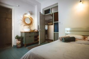 a bedroom with a bed and a mirror and a sink at וילה בקיבוץ דפנה - אירוח וטיולים בלב טבע פראי in Metsudat Menahem Ussishkin Alef