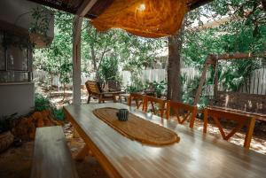 a patio with a table and benches and trees at וילה בקיבוץ דפנה - אירוח וטיולים בלב טבע פראי in Metsudat Menahem Ussishkin Alef