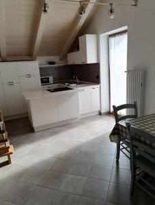 uma cozinha com armários brancos e piso em azulejo em Appartamenti Vegaia em Peio mais 12 fotografias