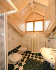 um banheiro com duas pias e um vaso sanitário em Appartamenti Vegaia em Peio