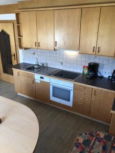 a kitchen with wooden cabinets and a sink at Haus Fuetsch in Virgen