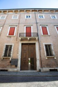 a large brick building with a large wooden door at Loft In Centro in Forlì