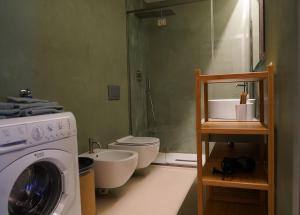 a bathroom with a washing machine and a toilet at Loft In Centro in Forlì +6 photos