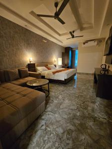 a hotel room with a bed and a couch at Hotel Cedara in Haldwāni