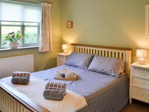 a bedroom with a bed with two dishes on it at Lily Broad Cottage in Burgh Saint Margaret +12 photos