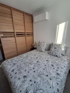 a bedroom with a large bed with a floral bedspread at Gîte du Papillon CALUTRE in Carvin