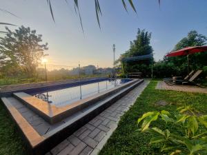 una piscina en un parque con sombrilla en D'Jongke Village, en Beran-kidul