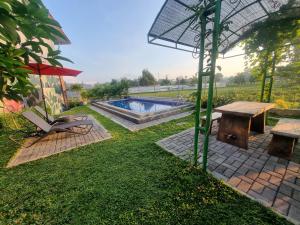 Un jardín con una mesa de picnic y una sombrilla. en D'Jongke Village, en Beran-kidul 16 fotos más