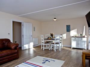 a living room with a table and chairs and a kitchen at Orestone Garden Apartment in Dawlish