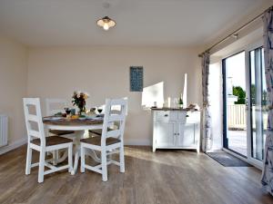 a white dining room with a table and chairs at Orestone Garden Apartment in Dawlish +10 photos