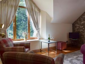 Henrys MoatにあるThe Granary - Hw7187の椅子2脚とテーブル、窓のあるリビングルーム