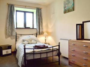 a bedroom with a bed with a teddy bear on it at Willow Cottage in Ambleside