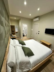 ein Schlafzimmer mit einem großen Bett mit weißer Bettwäsche und grünen Kissen in der Unterkunft Silvana Guest House in Neapel