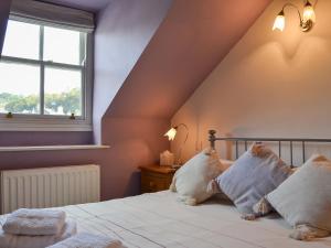 a bedroom with a bed with white pillows and a window at Fell View in Ambleside